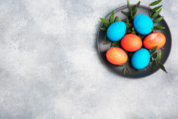 Easter eggs painted by hand colored on a concrete table, top view. copy space