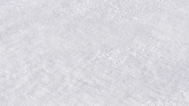 Cold breeze blowing swirls of powdery snow over frozen white ground - Detail shot