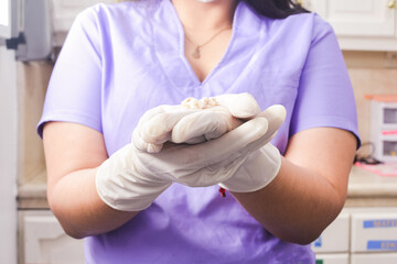 A female dentist showing false teeth. Una odontóloga mostrando unos dientes postizos.