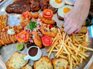 Big pan steak, partially blurry With pork, chicken, fried shrimp, bread and salad