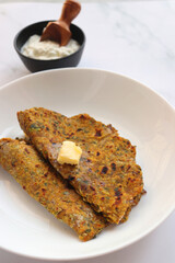 Radish or Mooli masala Paratha served on a white plate with butter cubes. Served with curd, pickle, and green chili. copy space. Muli ke parathe. Radish masala roti.