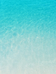 Fototapeta na wymiar Light blue sea waves on a sandy beach background.