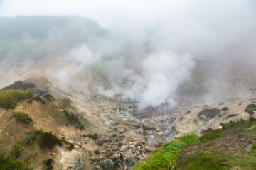 Mysterious view of volcanic landscape, aggressive hot spring, erupting fumarole, gas-steam activity in crater of active volcano. Beautiful mount landscape, travel destinations for hike, vacation.