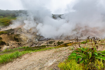Exciting view of volcanic landscape, erupting fumarole, aggressive hot spring, gas-steam activity in crater of active volcano. Dramatic mount landscape, travel destinations for active vacation, hike.