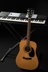 Fototapeta na wymiar Acoustic guitar and synthesizer on dark background