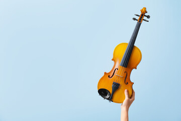 Woman holding violin on color background © Pixel-Shot