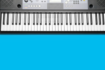 Modern synthesizer on color background, closeup