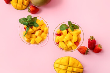 Glass bowls with mango salad on color background