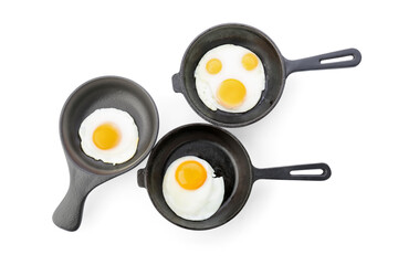 Pans with tasty fried eggs on white background