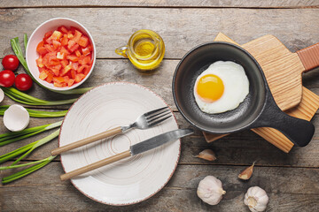 Frying pan with tasty egg on table