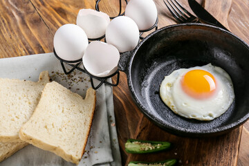 Frying pan with tasty egg on table