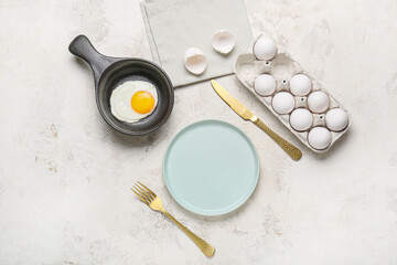 Obraz na płótnie Canvas Frying pan with tasty egg on light background