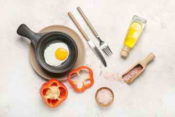 Frying pan with tasty egg on light background