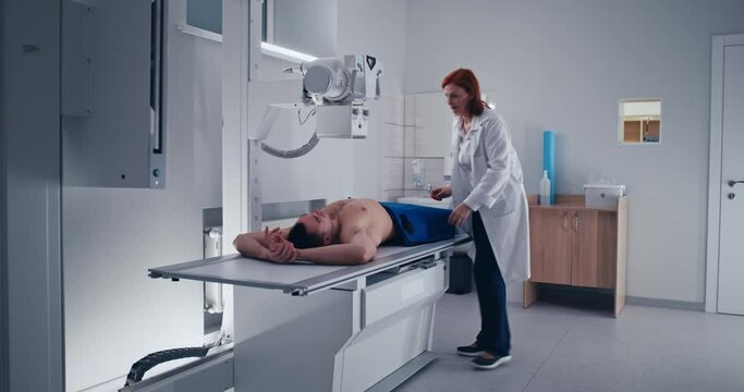 Female doctor doing chest X ray scan of male patient