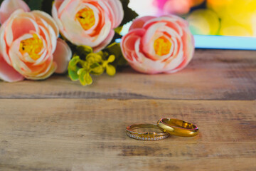 Duo Golden wedding ring with flowers on  background.