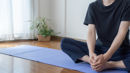 A man stretching at home. Stretched legs:Open legs:Hamstring stretch