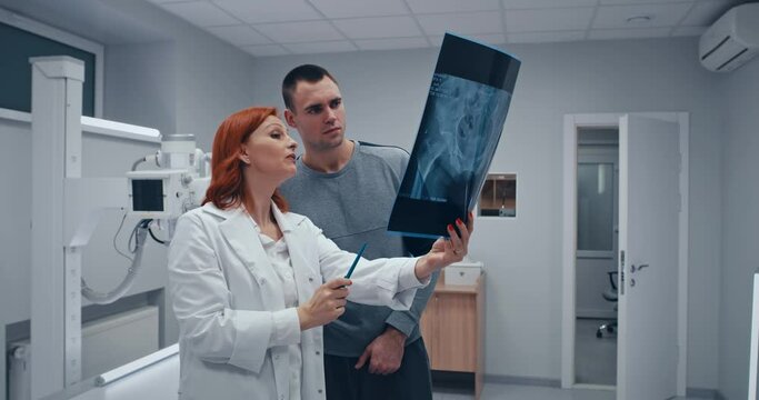 Mature doctor showing X ray scan to patient