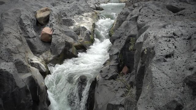 volcanic rock of Sicily nature split by a fault and smoothed by the waters flowing in a gorge of Simeto river 