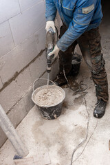 A worker kneads the mixture into plaster buckets. Home renovation