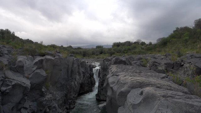volcanic rock of Sicily nature split by a fault and smoothed by the waters flowing in a gorge of Simeto river 