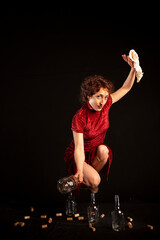 Mujer artista de circo en equilibrio sobre botellas sobre fondo negro de estudio