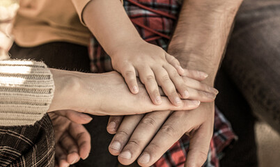 Child hand closeup into parents. Hands of father, mother, keep hand little baby. Parents hold the...