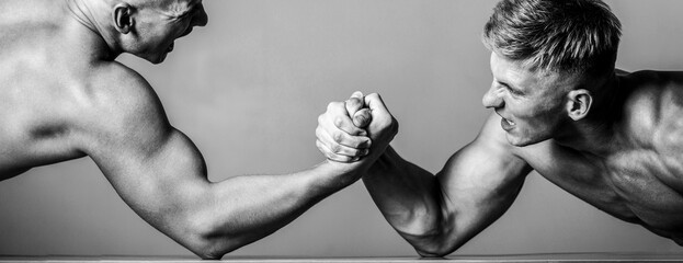 Arm wrestling. Two men arm wrestling. Rivalry, closeup of male arm wrestling. Two hands. Men measuring forces, arms. Hand wrestling, compete. Hands or arms of man. Muscular hand. Black and white