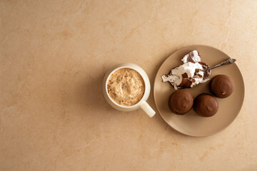 Obraz na płótnie Canvas Cup of fragrant coffee and chocolate covered marshmallow over marble background with copy space.