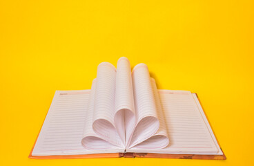 Blank notebook on yellow background.