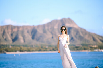 Girl wearing white long dress by the sea, Honolulu, Oahu, Hawaii