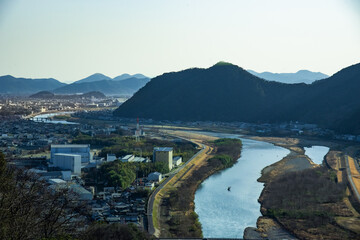兵庫県たつの市・東を頭に横たわり休むブッダの山影、揖保川に風のない春の午後の陽光