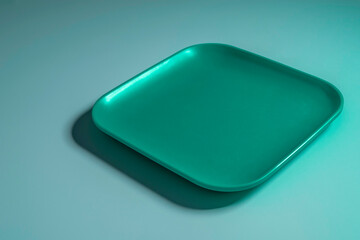 Empty emerald tray over blue background.