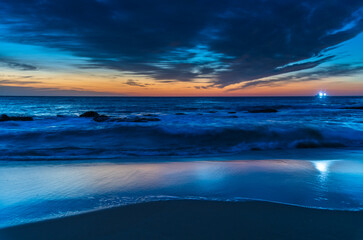 Obraz premium Sunrise at the beach with high cloud and boat with lights