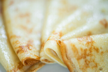 Thin homemade pancakes. Light background. Beautiful and delicious breakfast at home or in the cafe. Selective focus