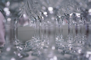 glasses stand in a row and glare in the light at a cocktail party