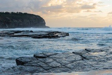 Sunrise view around rock shelf on the beach.