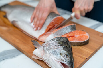 the process of cutting a trout carcass with a kitchen knife