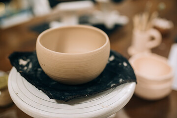 Finished clay products stand on a stand and dry in the sculptor's workshop