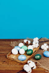 Obraz premium Easter eggs on a wooden board and blue background in the background 