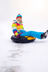 Fototapeta na wymiar Wintersport Activities. Lovely Caucasian Girl Having Tube Activities In Winter Time And Sliding Downhill In Mountains.