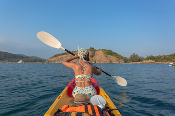 tourist canoeing in front of Yanui Beach. Yanui Beach is  between Nai Harn Beach and Laem Phromthep Viewpoint and there is the Isle of Man in front, making the sea calm and suitable for canoeing..
