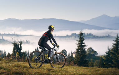 Male cyclist riding bicycle in mountains.