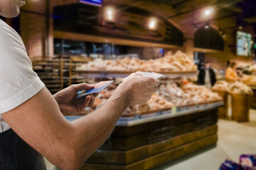 Closeup of customer paying for purchase in supermarket by credit card