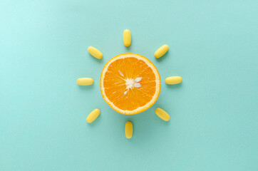 Abstract idea.Top view of orange and yellow capsules on the blue background.Concept of healthcare and vitamins