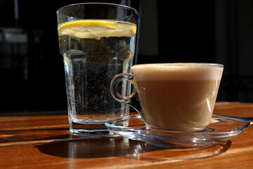 Fresh hot coffee on wooden table in cafe interior
