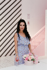 brunette girl in a blue dress with a glass of red wine