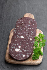 Traditional black pudding sausage slices on black stone background