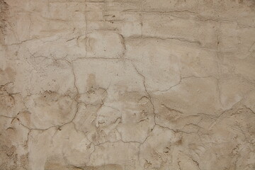 Rough brown old dry clay plastered wall surface with cracks - texture for background