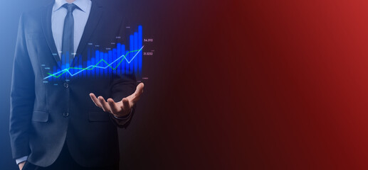 Fototapeta na wymiar Business man holding holographic graphs and stock market statistics gain profits. Concept of growth planning and business strategy. Display of good economy form digital screen.