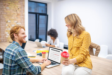 Ginger guy talking to a blone female colleague in the office